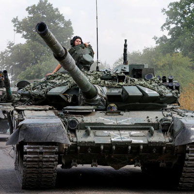 Soldiers driving two tanks down the road